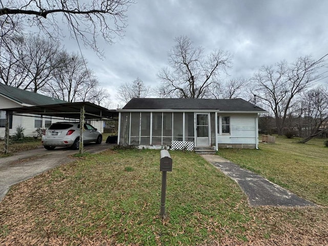 view of front of property featuring a sunroom and a front lawn