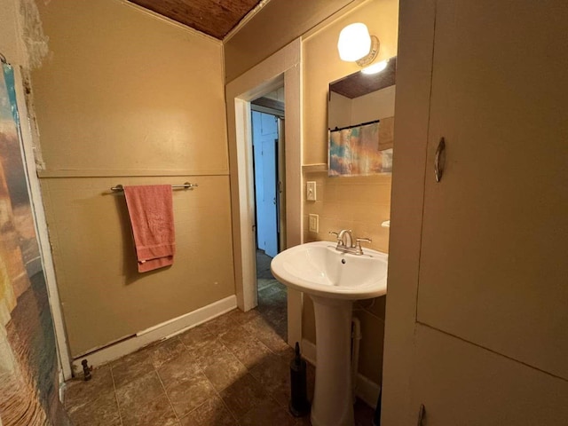 bathroom featuring tile walls and sink