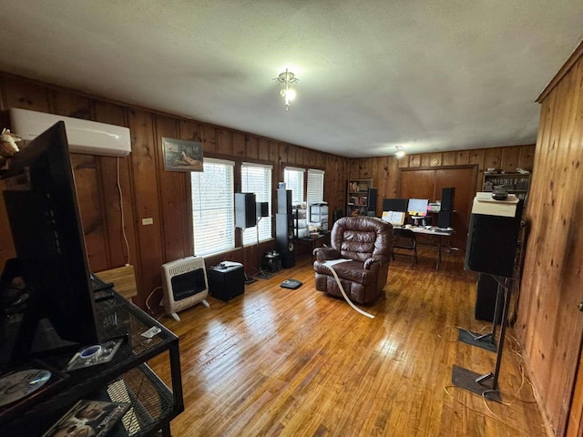 living room featuring wooden walls, heating unit, and light hardwood / wood-style floors