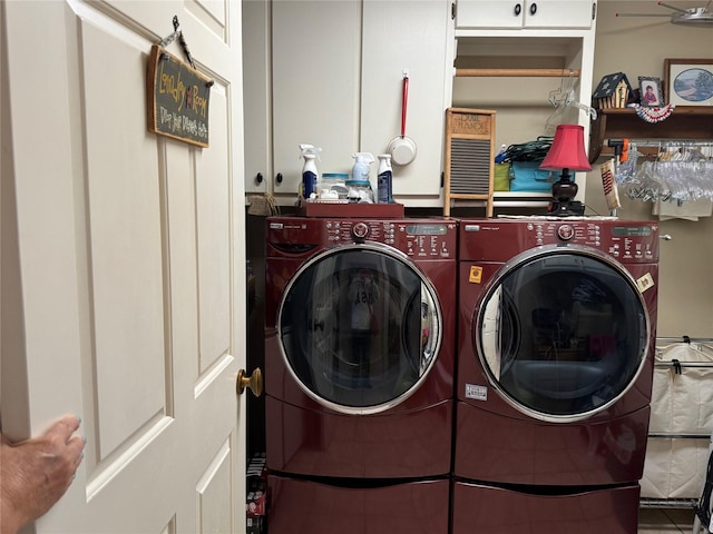 washroom featuring washing machine and dryer and cabinets