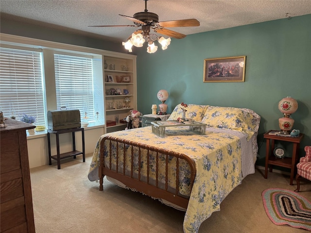 carpeted bedroom featuring ceiling fan and a textured ceiling