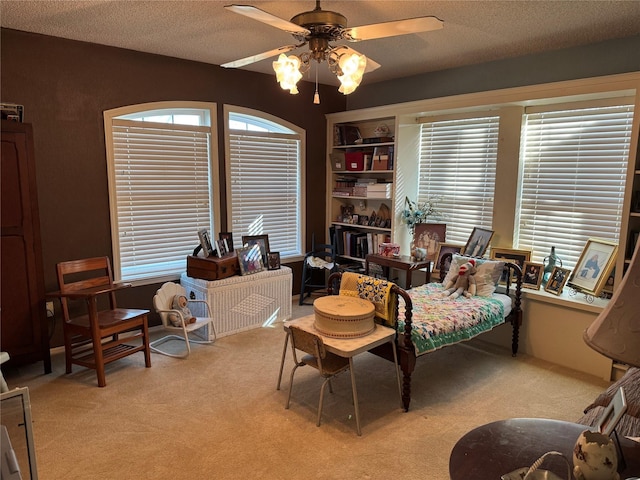 sitting room with light carpet, a textured ceiling, plenty of natural light, and ceiling fan