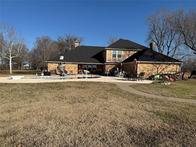 rear view of property with a yard and a patio area