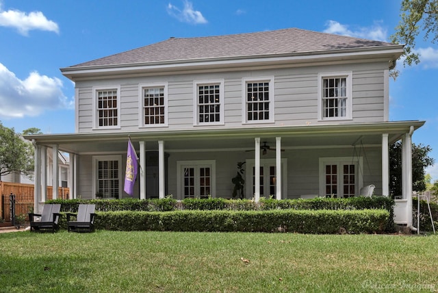 view of front of home with french doors, ceiling fan, and a front lawn