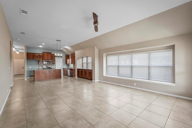 unfurnished living room with light tile patterned floors, ceiling fan with notable chandelier, and vaulted ceiling