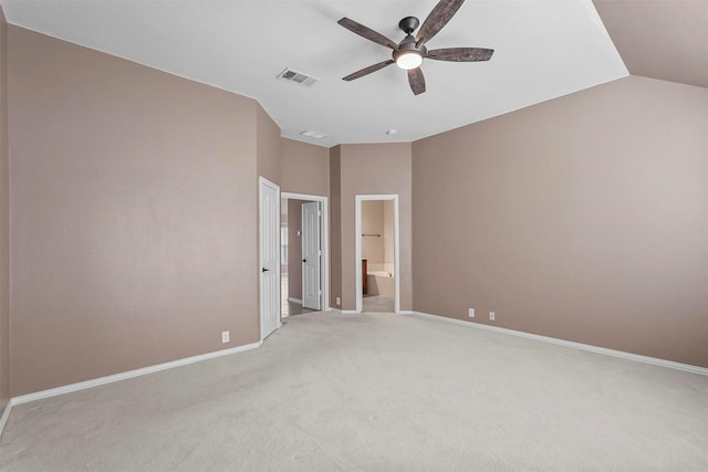 unfurnished bedroom featuring vaulted ceiling, light colored carpet, ceiling fan, and ensuite bath