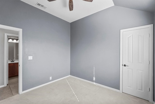 unfurnished room with sink, vaulted ceiling, light colored carpet, and ceiling fan