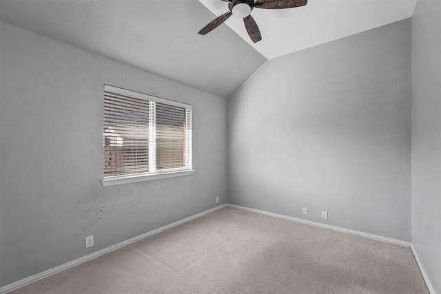 carpeted spare room featuring ceiling fan and vaulted ceiling