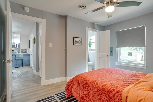 bedroom featuring connected bathroom, ceiling fan, and light hardwood / wood-style flooring