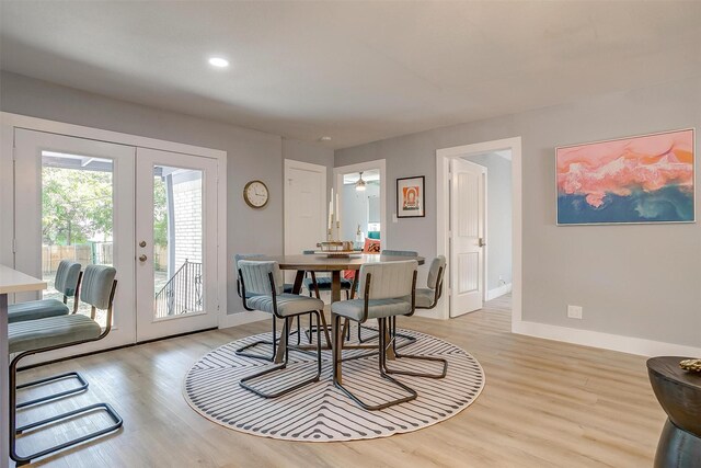 dining room with ceiling fan, french doors, and light wood-type flooring