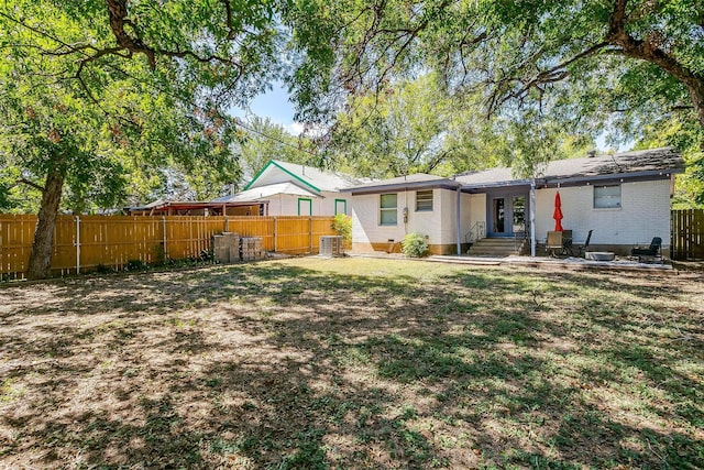 rear view of property with a yard and central AC