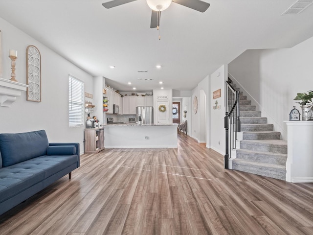 living room with light wood-type flooring and ceiling fan