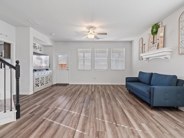 living room featuring ceiling fan and hardwood / wood-style flooring