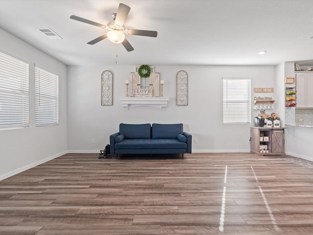 living area with ceiling fan, a healthy amount of sunlight, and hardwood / wood-style floors