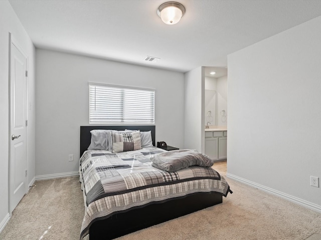 carpeted bedroom featuring ensuite bath