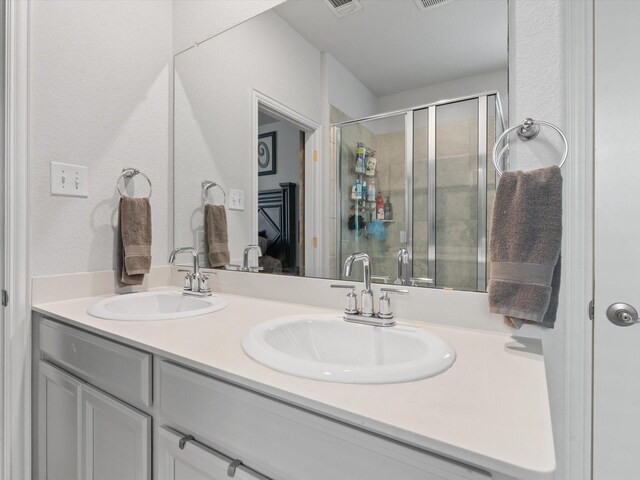 bathroom with a shower with door and vanity