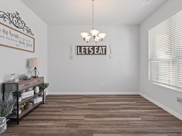 dining space with a chandelier and dark hardwood / wood-style flooring