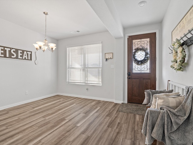 entryway featuring light hardwood / wood-style flooring and an inviting chandelier