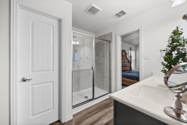 bathroom featuring walk in shower, vanity, and hardwood / wood-style floors