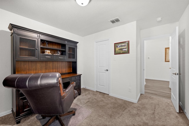 carpeted office space with a textured ceiling