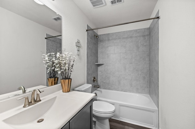 full bathroom with vanity, tiled shower / bath combo, wood-type flooring, and toilet