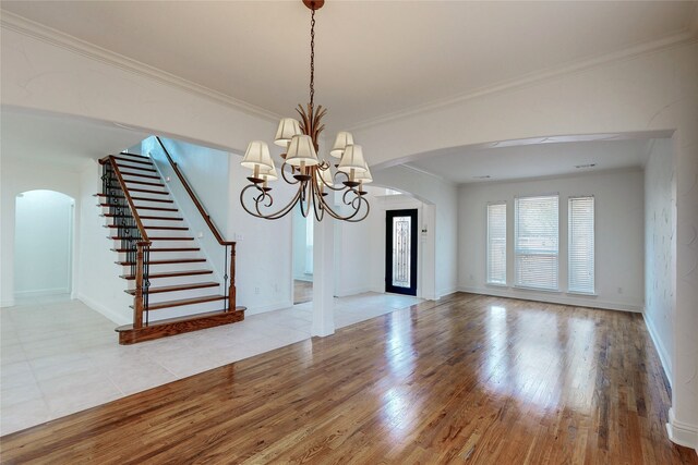 unfurnished dining area with crown molding, an inviting chandelier, and light hardwood / wood-style floors