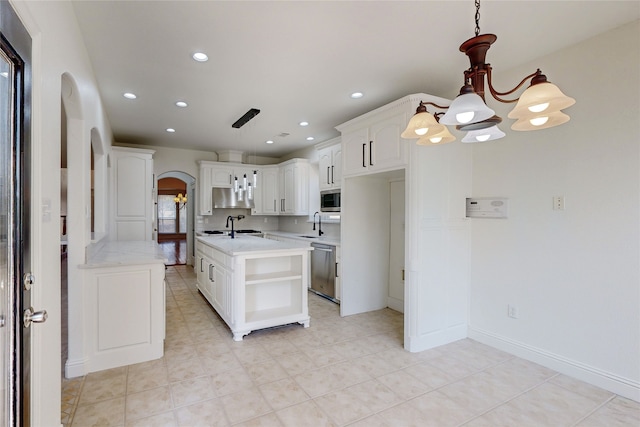 kitchen featuring sink, appliances with stainless steel finishes, an inviting chandelier, white cabinets, and decorative light fixtures