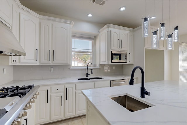 kitchen with light stone counters, sink, stainless steel appliances, and white cabinets