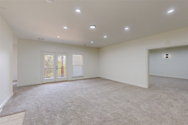 unfurnished room with french doors and light colored carpet