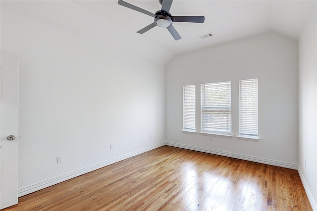 empty room with ceiling fan, lofted ceiling, and light wood-type flooring