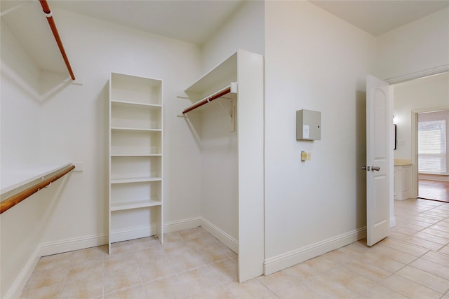 walk in closet with light tile patterned floors