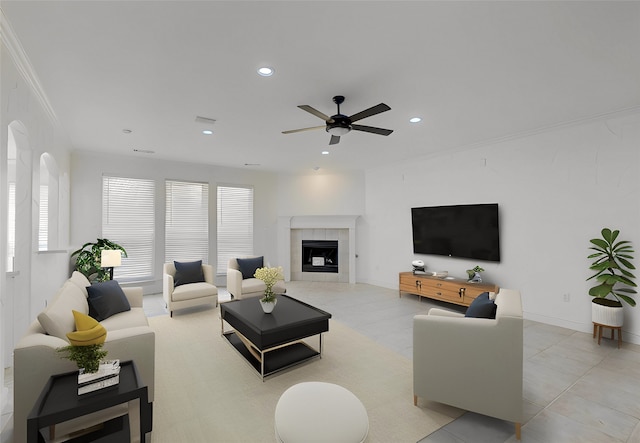 living room with a tile fireplace, crown molding, and ceiling fan