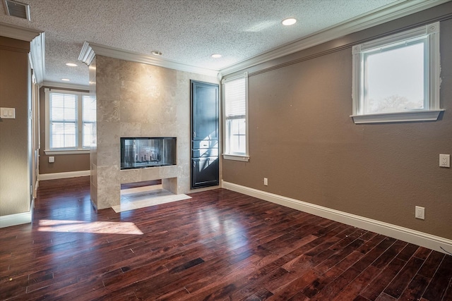 unfurnished living room with a multi sided fireplace, a textured ceiling, dark wood-type flooring, and crown molding