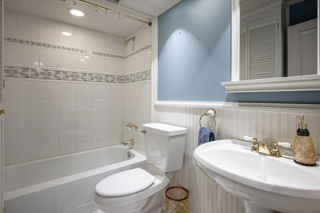 full bathroom with sink, tiled shower / bath combo, and toilet