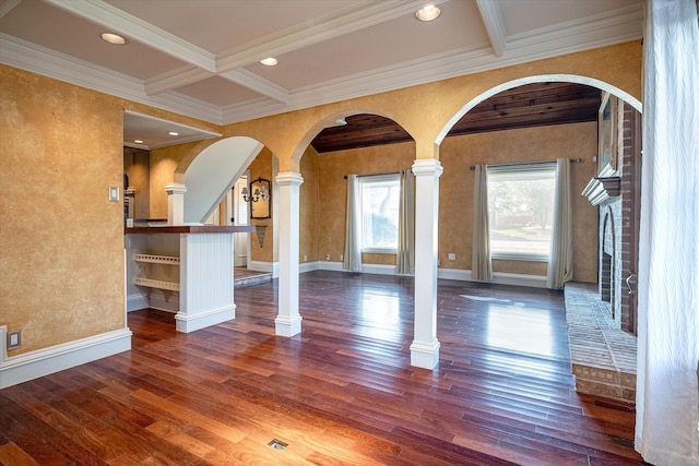 unfurnished living room with coffered ceiling, crown molding, dark hardwood / wood-style floors, ornate columns, and beam ceiling