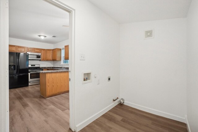 kitchen featuring stainless steel appliances, sink, and light wood-type flooring