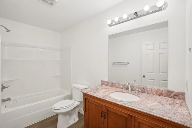 full bathroom with wood-type flooring, vanity, washtub / shower combination, and toilet