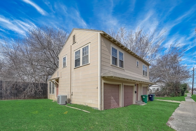 view of home's exterior featuring a garage, a yard, and central AC