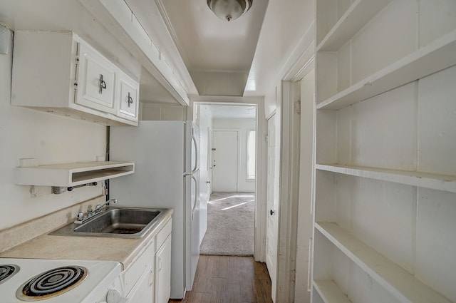 kitchen with white cabinetry, sink, hardwood / wood-style floors, and range