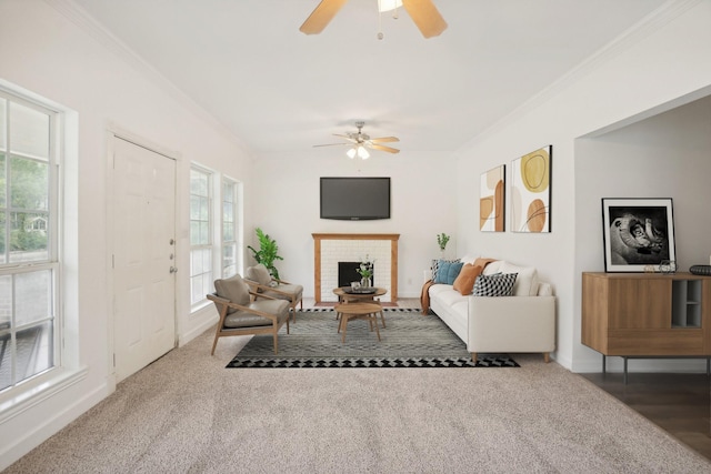 carpeted living room with ceiling fan, ornamental molding, and a brick fireplace