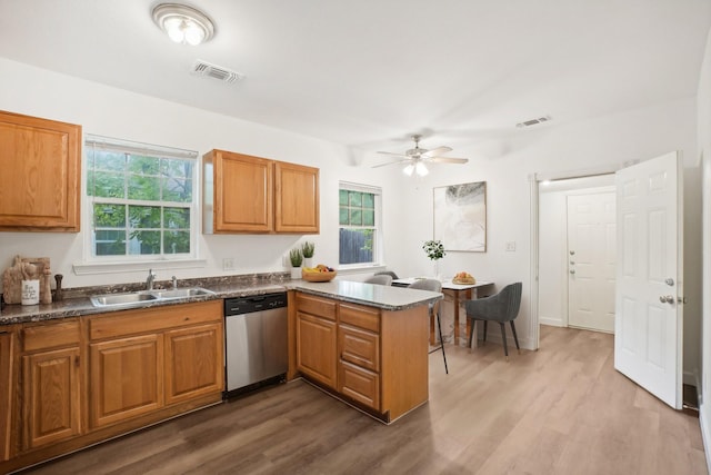 kitchen featuring sink, hardwood / wood-style flooring, stainless steel dishwasher, ceiling fan, and kitchen peninsula