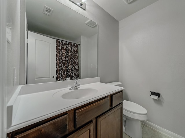 bathroom with tile patterned flooring, vanity, and toilet