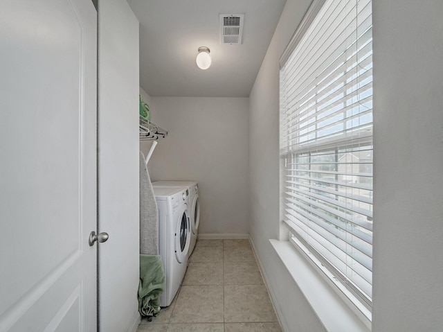 clothes washing area featuring separate washer and dryer and light tile patterned floors