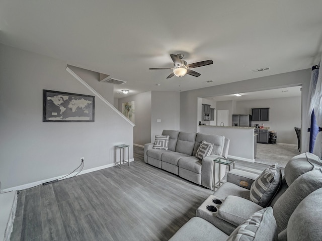 living room with wood-type flooring and ceiling fan