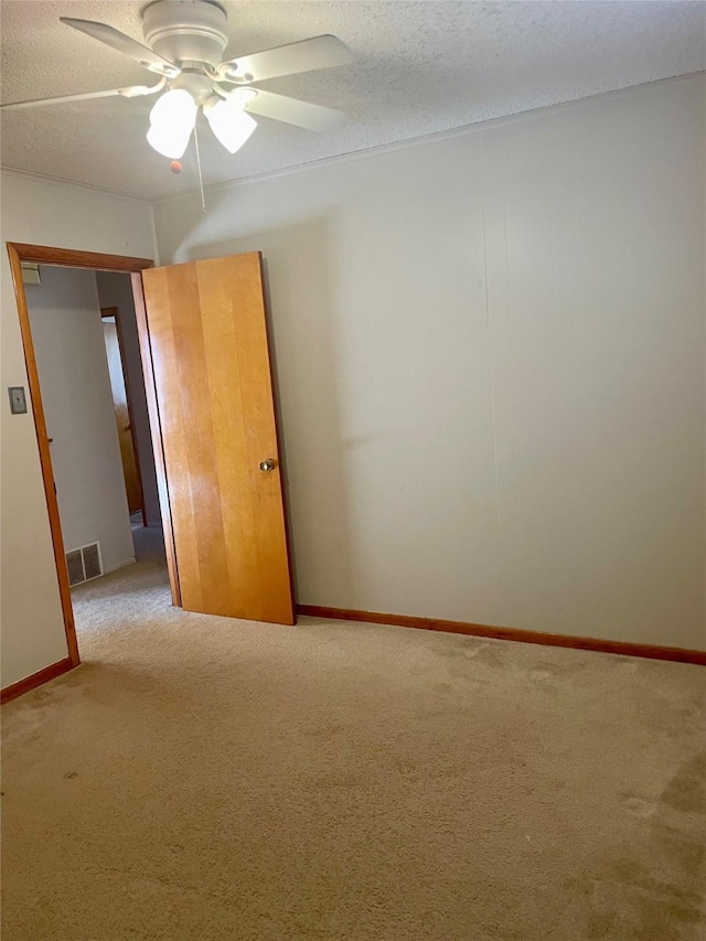 carpeted empty room with a textured ceiling and ceiling fan