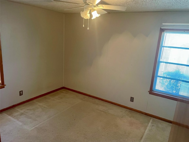 empty room featuring carpet flooring, ceiling fan, and a textured ceiling