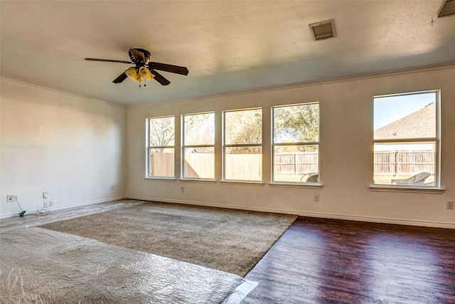 spare room featuring a textured ceiling, dark hardwood / wood-style flooring, ceiling fan, and ornamental molding