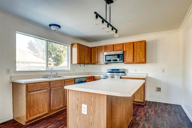 kitchen with appliances with stainless steel finishes, sink, a center island, dark hardwood / wood-style floors, and hanging light fixtures