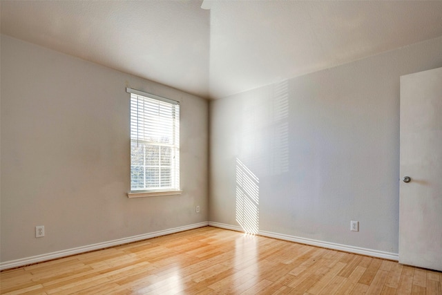 unfurnished room featuring light hardwood / wood-style floors and lofted ceiling