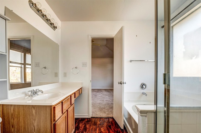 bathroom featuring separate shower and tub, vanity, and wood-type flooring